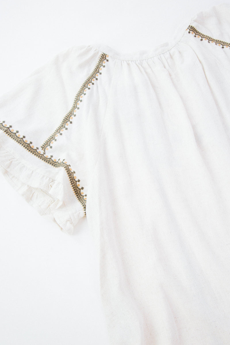 Back Detail shot of embroidered cream shirt on white background