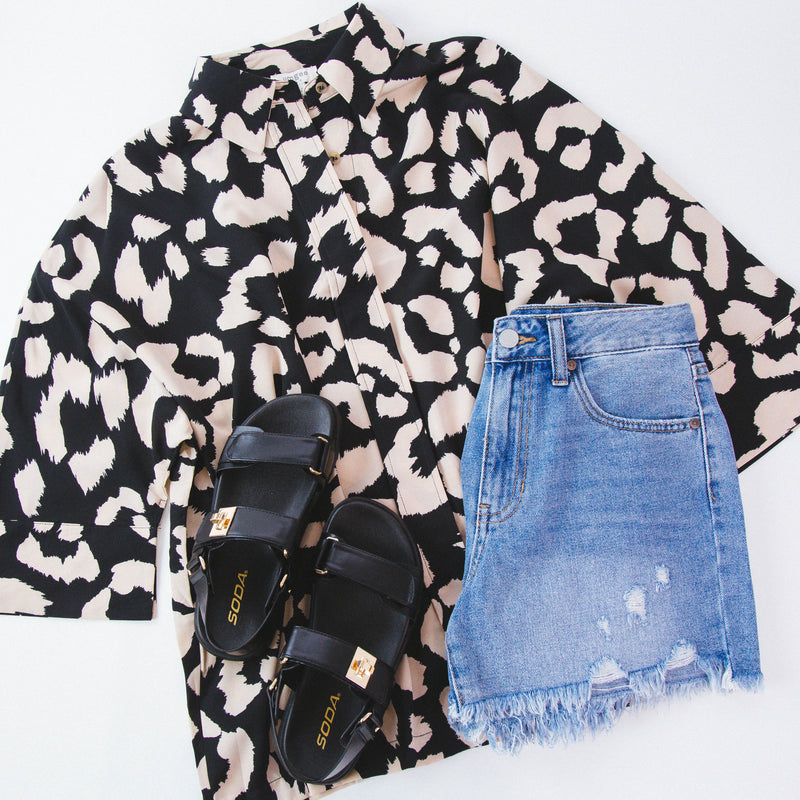 Black blouse with cream leopard print pattern featured with denim shorts and black sandals