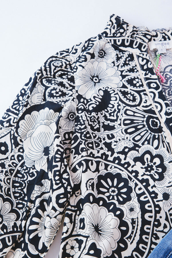 Detail shot of black and white paisley 3/4 sleeve top on a white background 