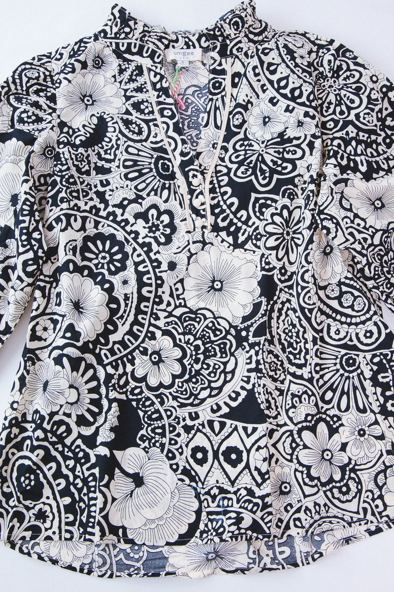 Detail shot of Black and white paisley 3/4 sleeve top on a white background